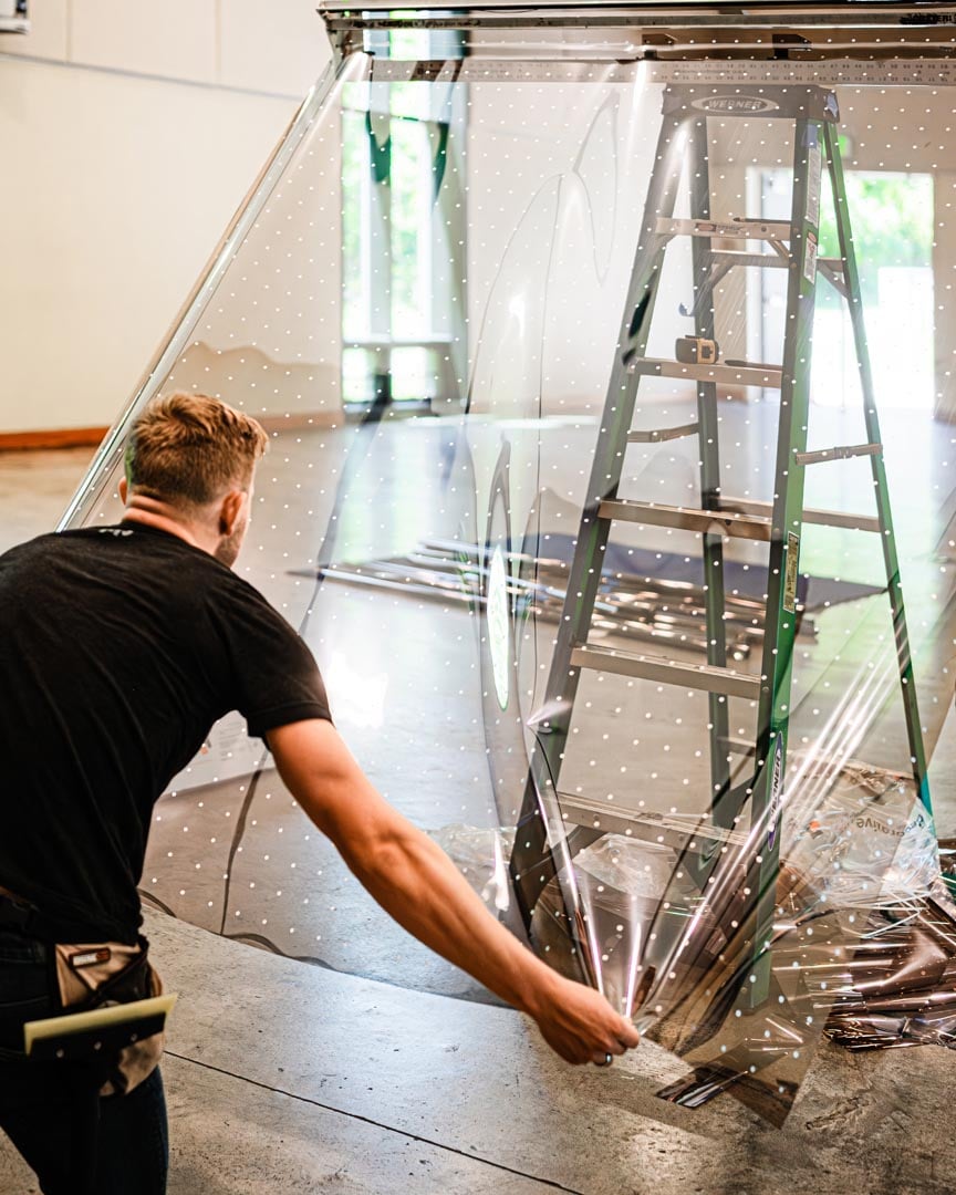 an installer prepares to install solyx solar bird safety film